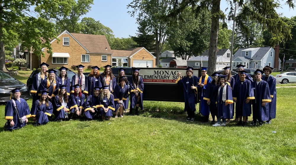 Grads in front of sign
