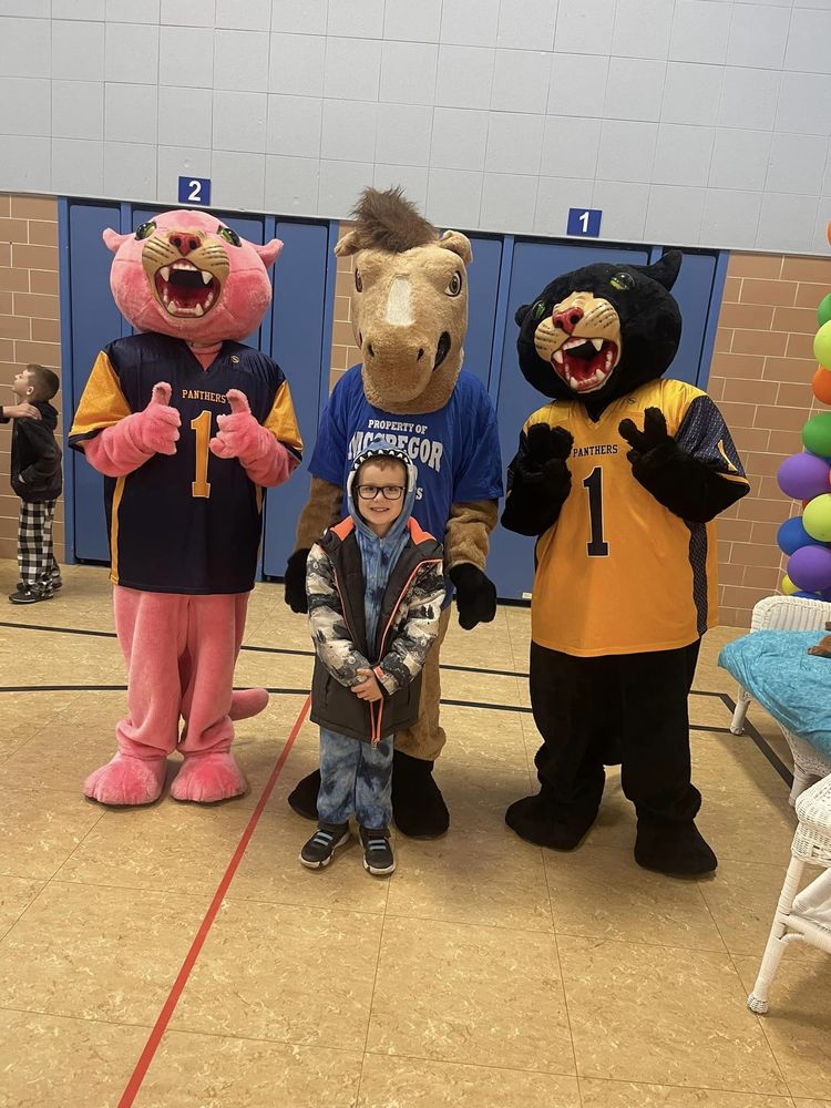 school mascots stand with child