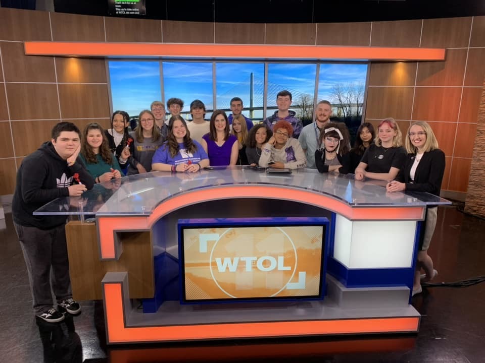 group of students standing around news desk at WTOL